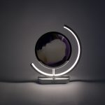 detaliu cu particulele de nisip violet cazand lent sub lumina led reglata